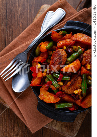 Steakhouse pfanne, fried potato slices, with meatballs, and vegetable mixture, on a black plate, 141512466
