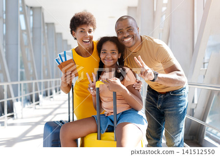 Black family of three at airport making peace signs while holding passports Black family of three at airport making peace signs while holding passports 141512550