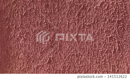 Full frame close up of a dusty rose terracotta stucco wall with rough irregular texture and a subtle light gradient across the surface. Full frame close up of a dusty rose terracotta stucco wall with rough irregular texture and a subtle light gradient across the surface. 141512622