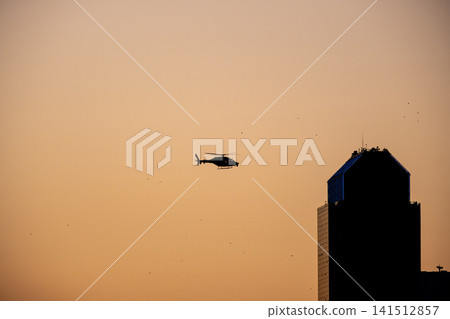 Sunset Helicopter Flying Through the Evening Sky. Sunset Helicopter Flying Through the Evening Sky. 141512857