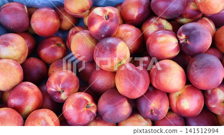 View of a large pile of fresh ripe nectarines View of a large pile of fresh ripe nectarines 141512994