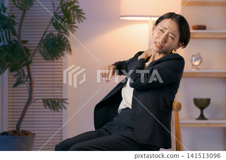 一位身穿西裝的女士,肩膀僵硬。 一位身穿西裝的女士,肩膀僵硬。 141513096