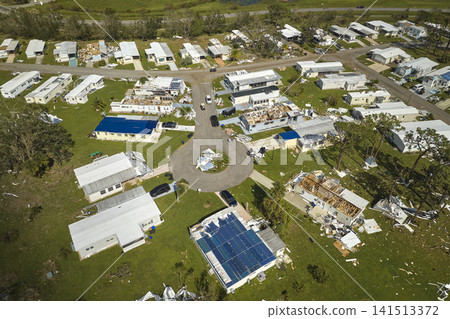 Severely damaged houses after hurricane Ian in Florida mobile home residential area. Consequences of natural disaster 141513372