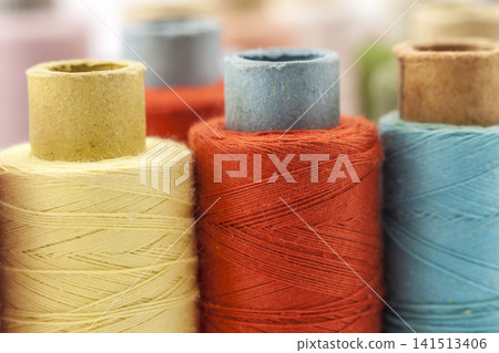 Reels or spools of multicolored sewing threads. Threads of all colors. Shallow depth of field. Close-up macro shot. Reels or spools of multicolored sewing threads. Threads of all colors. Shallow depth of field. Close-up macro shot. 141513406