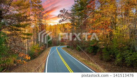 Peaceful mountain road in North Carolina during peak fall season at sunset. Appalachian landscape filled with vivid autumn colors Peaceful mountain road in North Carolina during peak fall season at sunset. Appalachian landscape filled with vivid autumn colors 141513476