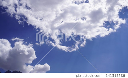 Bright daytime photograph of white fluffy cumulus clouds against a vibrant blue sky, sky scape concept. Bright daytime photograph of white fluffy cumulus clouds against a vibrant blue sky, sky scape concept. 141513586