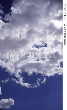 Dramatic photograph of a bright blue sky filled with wispy white clouds, creating a dynamic pattern, atmospheric concept. 141513587
