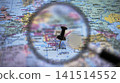 Exploring a map with a magnifying glass and a pin on Athens 141514552