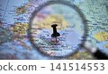 Exploring a map with a magnifying glass and a pin in Chisinau 141514553
