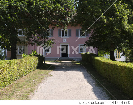 House with a pathway surrounded by trees and bushes in bright daylight House with a pathway surrounded by trees and bushes in bright daylight 141514558