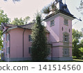 Historic building with pink exterior located in a green area 141514560