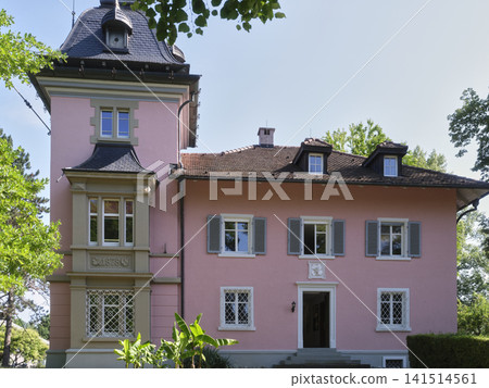 Historic house with pink walls surrounded by green trees in a park Historic house with pink walls surrounded by green trees in a park 141514561