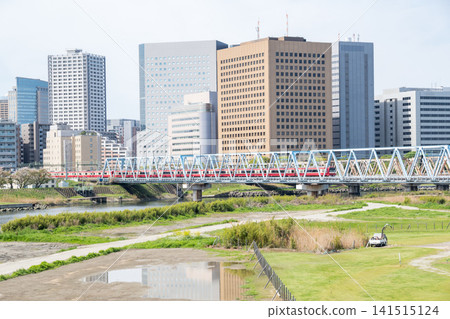 [Keikyu Main Line] A 12-car rapid express train bound for Shinagawa crosses the Tamagawa River. 141515124