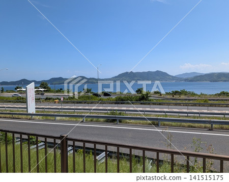 一塊寫著「歡迎來到廣島」的標誌牌,以及俯瞰瀨戶內海的高速公路景觀。 一塊寫著「歡迎來到廣島」的標誌牌,以及俯瞰瀨戶內海的高速公路景觀。 141515175