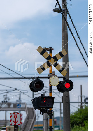 Level crossing warning lights and barriers illuminated by red warning lights. 141515766