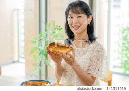 一個女人在吃麵包 141515939
