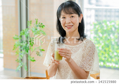 喝綠色汁液的婦女 141515980