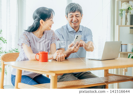 看著智能手機的年長夫婦 141516644