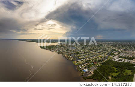 Tropical thunderstorm over Charlotte Harbor with dramatic dark clouds and rainfall pouring on Florida coastal town. 141517233
