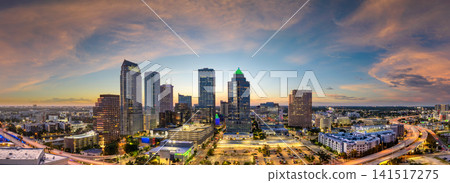 Tampa city in Florida with brightly illuminated skyscraper buildings in downtown district. American megapolis with business financial district at sunset Tampa city in Florida with brightly illuminated skyscraper buildings in downtown district. American megapolis with business financial district at sunset 141517275