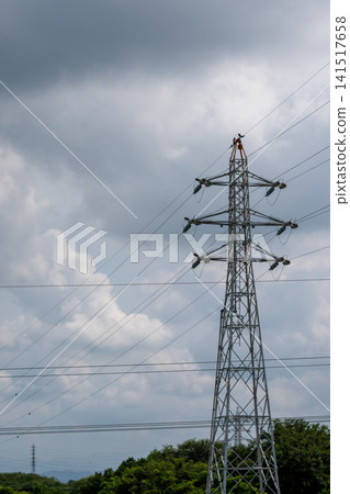Power transmission towers and high-voltage power lines stretching across a cloudy sky. Power transmission towers and high-voltage power lines stretching across a cloudy sky. 141517658