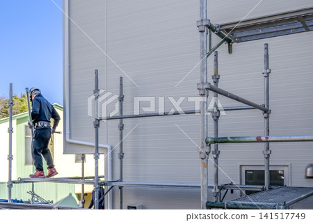Scaffolding dismantling work after exterior wall renovation is complete. Scaffolding dismantling work after exterior wall renovation is complete. 141517749