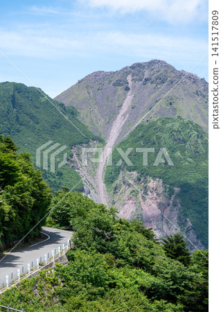 A vertical shot of Nita Pass, Nagasaki, showing the lush green mountain path and the rugged slopes of Mt. Heisei Shinzan. A vertical shot of Nita Pass, Nagasaki, showing the lush green mountain path and the rugged slopes of Mt. Heisei Shinzan. 141517809