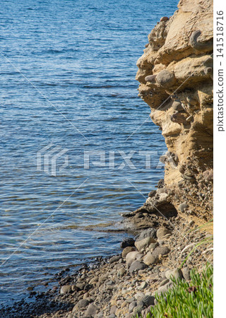 The gravel and eroded coastal strata that extend along the shoreline. The gravel and eroded coastal strata that extend along the shoreline. 141518716