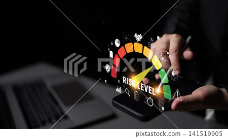 Hands holding smartphone with digital risk level gauge and icons indicating risk assessment, business strategy, and decision-making in dark environment Quark Hands holding smartphone with digital risk level gauge and icons indicating risk assessment, business strategy, and decision-making in dark environment Quark 141519905