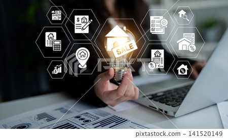 Business Professional Displaying Light Bulb with Sale Tag Surrounded by Real Estate Icons and Data Charts in Modern Office Setting. Glyphic Business Professional Displaying Light Bulb with Sale Tag Surrounded by Real Estate Icons and Data Charts in Modern Office Setting. Glyphic 141520149