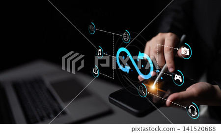 Hands using modern smartphone with futuristic technology interface and digital icons for connectivity and interaction in dark environment. Sentient Hands using modern smartphone with futuristic technology interface and digital icons for connectivity and interaction in dark environment. Sentient 141520688