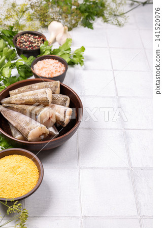 Preparing raw hake fish with spices and herbs Preparing raw hake fish with spices and herbs 141520976