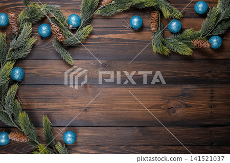 Christmas border pine branches with blue ornaments on wood Christmas border pine branches with blue ornaments on wood 141521037