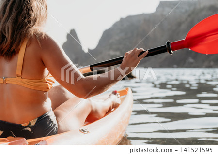 Kayaking Woman Paddle Mountain - Woman kayaking in scenic mountain setting on a sunny day. Kayaking Woman Paddle Mountain - Woman kayaking in scenic mountain setting on a sunny day. 141521595