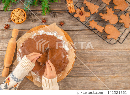 Making Christmas Gingerbread Cookies with Cookie Cutter on Rustic Table Making Christmas Gingerbread Cookies with Cookie Cutter on Rustic Table 141521861