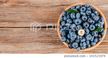 Fresh Blueberries in Wooden Bowl on Rustic Wooden Table with Copy Space Fresh Blueberries in Wooden Bowl on Rustic Wooden Table with Copy Space 141521974
