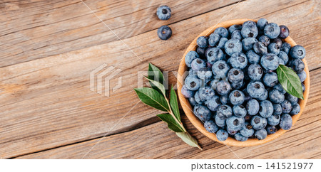 Fresh Blueberries in Wooden Bowl on Rustic Wooden Table Top View 141521977