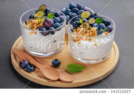 Blueberry chia yogurt parfait with granola on wooden board close up Blueberry chia yogurt parfait with granola on wooden board close up 141522027