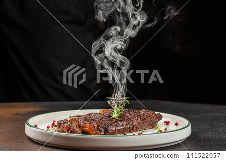 Juicy Grilled Beef Steak with Rosemary and Rising Aromatic Smoke Juicy Grilled Beef Steak with Rosemary and Rising Aromatic Smoke 141522057