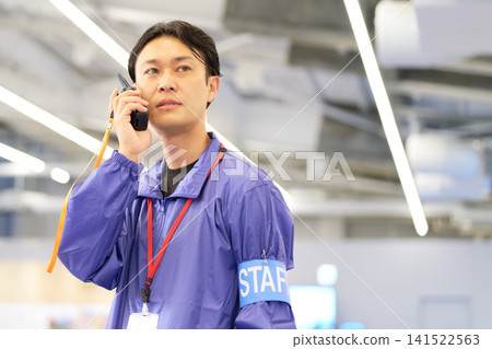 Event staff communicating via radio 141522563