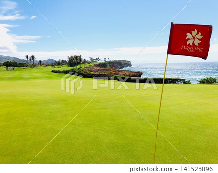 The red pin flag and the Pacific Ocean at Poipu Bay Resort Golf Course on Kauai. The red pin flag and the Pacific Ocean at Poipu Bay Resort Golf Course on Kauai. 141523096