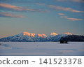 A sunset view of the Echigo Sanzan mountains against a backdrop of a blue sky with white clouds drifting across it, as seen from the snowfields of Ikegahara in Ojiya City. 141523378