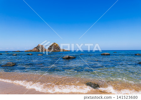 A clear blue sky, a beautiful, crystal-clear sea, and a coastal landscape. 141523680