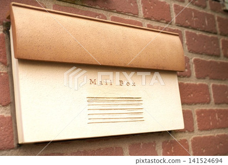 A mailbox attached to a brick wall, viewed from a diagonal angle. A mailbox attached to a brick wall, viewed from a diagonal angle. 141524694