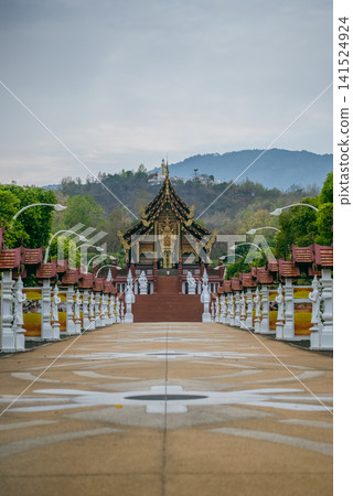Traditional Thai temple in Rajapruek park with symmetrical pathway and statues in Chiang Mai, Ornate Asian shrine architecture with stairs and cultural landmark in Thailand 141524924