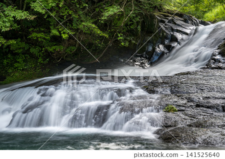 A clear waterfall flowing in summer A clear waterfall flowing in summer 141525640