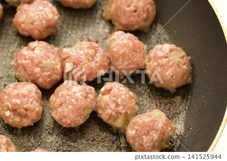 Cheese-filled meatballs cooking in a frying pan Cheese-filled meatballs cooking in a frying pan 141525944