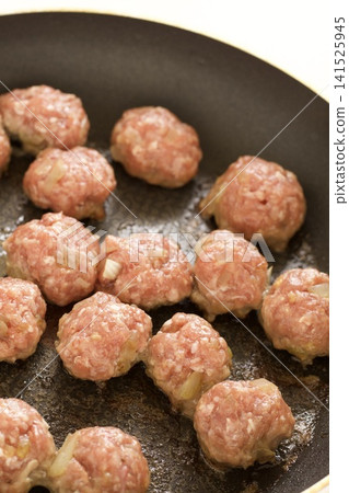 Cheese-filled meatballs cooking in a frying pan Cheese-filled meatballs cooking in a frying pan 141525945