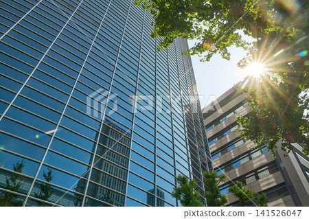The city's business district landscape is highlighted by the rays of sunlight and the beautiful glass architecture. The city's business district landscape is highlighted by the rays of sunlight and the beautiful glass architecture. 141526047