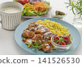 A lunch set featuring butter chicken curry and colorful vegetables served on a blue plate. 141526530